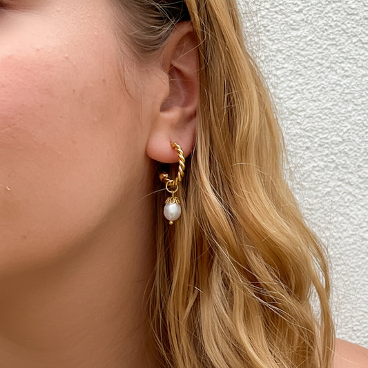 Boucles d’oreilles Perlina — Ces petites créoles torsadées en acier inoxydable plaquées or sont ornées de perles en résine n